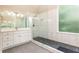 Bright bathroom featuring a walk-in shower, a vanity, and stone tile flooring at 9360 Nesbit Lakes Dr, Alpharetta, GA 30022