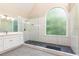 Bathroom featuring a walk-in shower, a vanity, and a marble-tiled wall at 9360 Nesbit Lakes Dr, Alpharetta, GA 30022