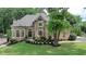 Elegant brick home with well-manicured lawn, mature trees, and beautiful architectural details at 9360 Nesbit Lakes Dr, Alpharetta, GA 30022