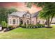 Attractive brick home with lush lawn, professional landscaping, and classic design elements at 9360 Nesbit Lakes Dr, Alpharetta, GA 30022