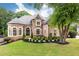 Charming brick home featuring a well-manicured lawn and lush landscaping at 9360 Nesbit Lakes Dr, Alpharetta, GA 30022