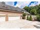 Spacious three car garage with brick exterior and ample parking on a private driveway at 9360 Nesbit Lakes Dr, Alpharetta, GA 30022