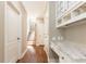 Hallway featuring a built-in desk, hardwood floors, and stair access at 9360 Nesbit Lakes Dr, Alpharetta, GA 30022