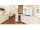 Bright kitchen with white cabinets, stainless steel appliances, hardwood floors, and a wine cooler at 9360 Nesbit Lakes Dr, Alpharetta, GA 30022