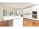 Bright kitchen featuring white cabinets, stainless steel appliances, hardwood floors and many windows at 9360 Nesbit Lakes Dr, Alpharetta, GA 30022
