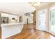 Bright kitchen with stainless steel appliances, white cabinets, an island, and hardwood floors at 9360 Nesbit Lakes Dr, Alpharetta, GA 30022