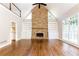 Open living room with hardwood floors, stone fireplace, and custom built-ins at 9360 Nesbit Lakes Dr, Alpharetta, GA 30022