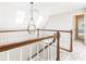 Second-story staircase landing with skylights and decorative pendant light, offering an airy feel at 9360 Nesbit Lakes Dr, Alpharetta, GA 30022