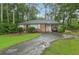 Charming brick home features a well-manicured lawn and mature trees, complemented by a convenient attached carport at 1849 Clay Sw Rd, Mableton, GA 30126