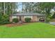 Charming brick home featuring a well-manicured lawn and lush landscaping, complete with an attached carport at 1849 Clay Sw Rd, Mableton, GA 30126