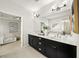 Bright bathroom with a dual sink vanity featuring black cabinets and white countertops adjacent to a bedroom at 1922 Perry Nw Blvd, Atlanta, GA 30318