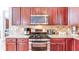 Kitchen featuring stainless steel appliances, granite countertops, tiled backsplash, and cherry wood cabinets at 4084 Fort Sumter Nw Lndg, Acworth, GA 30101
