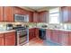Kitchen with stainless steel appliances, granite countertops, tiled backsplash, and cherry wood cabinets at 4084 Fort Sumter Nw Lndg, Acworth, GA 30101
