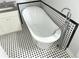 Bathroom features white tub and black and white tile at 1539 Beecher Sw St, Atlanta, GA 30310