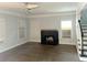 Bright living room with hardwood floors, fireplace, large windows, and stairs to the second floor at 1539 Beecher Sw St, Atlanta, GA 30310