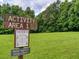 Community activity area with a wooden sign surrounded by greenery and open space at 1980 Deco Dr, Kennesaw, GA 30144
