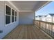 Spacious outdoor patio with wooden flooring, grey wood-paneled wall, and a view of neighboring homes at 1980 Deco Dr, Kennesaw, GA 30144