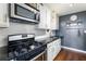 Well lit kitchen featuring stainless steel appliances, white cabinets, subway tile backsplash, and hardwood floors at 215 Piedmont Ne Ave # 1406, Atlanta, GA 30308