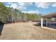 Large, flat backyard with a covered patio, fence, and mature trees at 7434 Absinth Dr, Atlanta, GA 30349