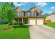 Charming two-story brick home featuring a well-manicured lawn and a two-car garage at 7434 Absinth Dr, Atlanta, GA 30349