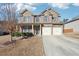 Two-story brick home with a two-car garage and mature landscaping in the front yard at 7434 Absinth Dr, Atlanta, GA 30349