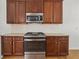 Close-up of kitchen with stainless steel oven and microwave, granite countertops, and dark cabinets at 7434 Absinth Dr, Atlanta, GA 30349