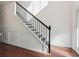 Bright interior featuring a staircase with black iron railings and decorative wall paneling at 7434 Absinth Dr, Atlanta, GA 30349