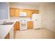 Modern kitchen with tile flooring, wooden cabinets, and white appliances at 2426 Fairlie Dr, Duluth, GA 30096
