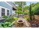 Landscaped backyard with a stone fire pit, lush plants, and a view of the upper-level balcony at 1912 Hosea L Williams Ne Dr # 1, Atlanta, GA 30317