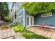 Inviting backyard patio with stone pavers, manicured greenery, and a charming Kirkwood sign on the blue siding at 1912 Hosea L Williams Ne Dr # 1, Atlanta, GA 30317