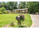 Charming home with a lush green lawn, mature trees, and a welcoming mailbox adorned with purple flowers at 272 Creek Sw Ct, Marietta, GA 30064