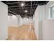 Spacious unfinished basement with wooden floors and exposed ceiling at 3422 Maplehurst Dr, Decatur, GA 30032