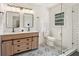 Elegant bathroom with double vanities, a glass-enclosed shower, and stylish patterned tile flooring at 3422 Maplehurst Dr, Decatur, GA 30032