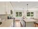 Bright kitchen with white cabinets, quartz countertops, stainless appliances, and a view into the living room at 3422 Maplehurst Dr, Decatur, GA 30032
