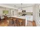 Modern kitchen with white cabinets, stainless steel appliances, an island with seating, and hardwood floors at 3422 Maplehurst Dr, Decatur, GA 30032
