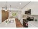 Modern kitchen featuring white cabinets, stainless steel appliances, granite countertops and a stylish dining area at 3422 Maplehurst Dr, Decatur, GA 30032