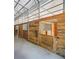 Barn interior featuring wooden stalls with metal bars on a concrete floor, designed for livestock or storage at 3842 Ernest W Barrett Sw Pkwy, Marietta, GA 30064