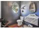 Stylish half bathroom with a round window, unique sink, faucet and decor at 3842 Ernest W Barrett Sw Pkwy, Marietta, GA 30064