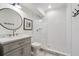 Modern bathroom featuring a walk-in shower with subway tile and a round mirror over the vanity at 3842 Ernest W Barrett Sw Pkwy, Marietta, GA 30064