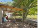 Outdoor chicken coop with chickens, feeders, and waterers, surrounded by trees and foliage in a shaded area at 3842 Ernest W Barrett Sw Pkwy, Marietta, GA 30064