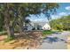 Two-story home showcasing white siding, dark window frames, asphalt drive, and a large shady tree at 3842 Ernest W Barrett Sw Pkwy, Marietta, GA 30064