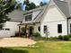 Charming white farmhouse exterior with a circular driveway and black trimmed windows at 3842 Ernest W Barrett Sw Pkwy, Marietta, GA 30064