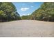 Fenced outdoor horse arena with sandy ground and a border of green trees at 3842 Ernest W Barrett Sw Pkwy, Marietta, GA 30064