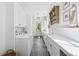 Well-lit laundry room with gray tile flooring, white cabinets and appliances at 3842 Ernest W Barrett Sw Pkwy, Marietta, GA 30064
