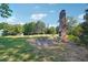 Outdoor patio area with fireplace on a grassy area with table and chairs, surrounded by trees and foliage at 3842 Ernest W Barrett Sw Pkwy, Marietta, GA 30064