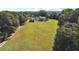 Sprawling green yard leads to the two-story white home, complemented by a charming fence at 3842 Ernest W Barrett Sw Pkwy, Marietta, GA 30064