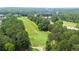 An aerial view of a meticulously maintained golf course surrounded by lush trees and a peaceful community at 428 Redwood Trl, Canton, GA 30114