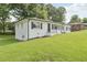 Angle shot of home showcasing white brick exterior, green lawn, and mature landscaping at 1261 Cliffwood Se Dr, Smyrna, GA 30080
