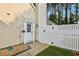 Close-up of the home's side entrance with a white door, decorative trim, and a fenced-in yard at 2657 Albion Farm Way, Duluth, GA 30097