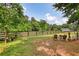 Scenic backyard featuring a fenced perimeter and outdoor seating area, surrounded by mature trees at 3508 Cox Cemetery Rd, Social Circle, GA 30025